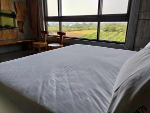 a bed in a room with a large window at 玉井-望明79 in Yujing