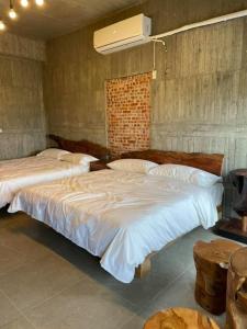 a bedroom with two large beds and a fan at 玉井-望明79 in Yujing