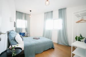 - une chambre avec un lit, une chaise et des fenêtres dans l'établissement Lapin Luxury Hotels By Nimizz, à Tel Aviv