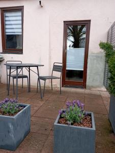 a patio with a table and chairs and purple flowers at Schenkgasse 4 in Amorbach