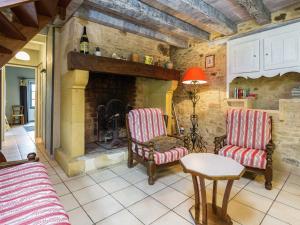 a living room with two chairs and a fireplace at Beautiful holiday home in wooded grounds near Villefranche du P rigord 7 km in Villefranche-du-Périgord