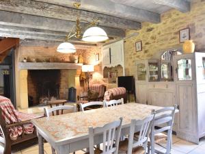 a dining room with a table and chairs and a fireplace at Beautiful holiday home in wooded grounds near Villefranche du P rigord 7 km in Villefranche-du-Périgord