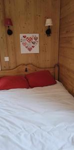 a bedroom with a large white bed with red pillows at appartement Gérardmer proche lac et centre ville in Gérardmer