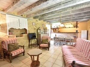 a living room with couches and a table and a kitchen at Beautiful holiday home in wooded grounds near Villefranche du P rigord 7 km in Villefranche-du-Périgord