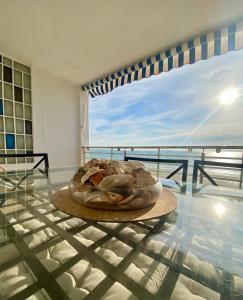 a glass table with a plate of food on it at Life Apartments Fuentebravía in El Puerto de Santa María