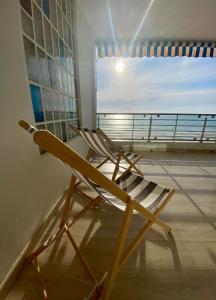 una silla de madera en una habitación con ventana en Life Apartments Fuentebravía, en El Puerto de Santa María