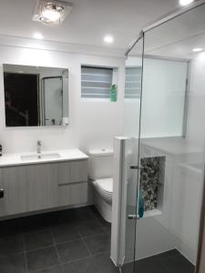 Un baño con inodoro, lavabo y ducha. en Bellevue, en Manyana 21 fotos más