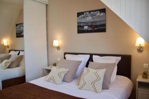 a bedroom with a bed with white sheets and pillows at La Goëlette in Sangatte