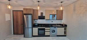 a kitchen with a refrigerator and a washing machine at Millénium vip parc appartement in Mohammedia