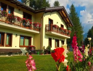 a building with flowers in front of it at Le Coin des Mélèzes - NATURE & TREK in Brusson