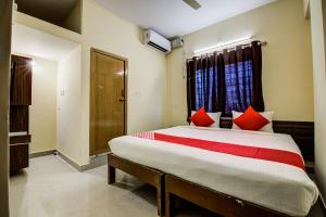 a bedroom with a large bed with red pillows at Flagship URBAN DRIFT in Yelahanka