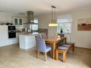 a kitchen with a wooden table and chairs in it at Grachtenkieker in Greetsiel