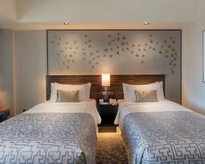 pokój hotelowy z 2 łóżkami i ścianą z kwiatami w obiekcie Cinnamon Grand Colombo w Kolombo