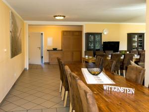 a dining room with a wooden table and chairs at Large apartment in the beautiful Sauerland with garden patio and sauna in Erndtebrück
