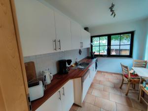 a kitchen with white cabinets and a counter top at Spacious semi detached house with wood stove located directly on the Rennsteig in Eisfeld
