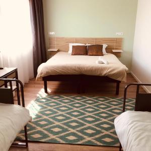 a bedroom with a large bed with a rug at Auberge du Fort Pélissier in Pont-Saint-Vincent