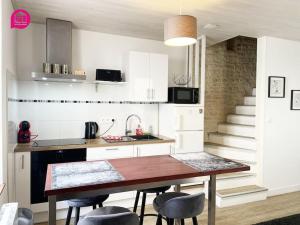 eine Küche mit einem Tisch und Stühlen sowie eine Treppe in der Unterkunft Le Paul by iZiLi - Centre Ville - Gare in Niort