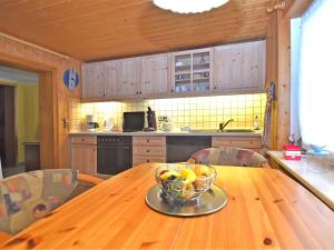 Comfortable holiday home in the Weser Uplands with saunas and solarium في Schieder-Schwalenberg: مطبخ مع طاولة خشبية مع وعاء من الفواكه