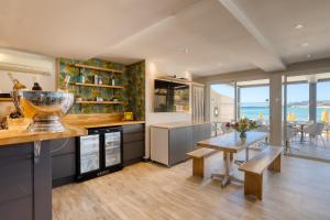 a kitchen with a table and a dining room at Roc Hotel - Hôtel 4 étoiles les pieds dans l'eau in Le Lavandou