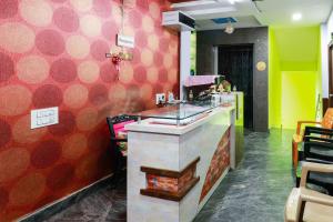 a restaurant with a counter and a red wall at OYO Raghava Guest House in Hyderabad