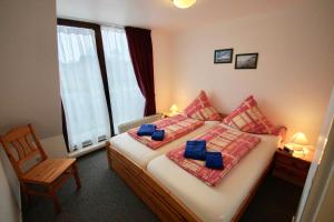 ein Schlafzimmer mit einem Bett mit einem Stuhl und einem Fenster in der Unterkunft FeWo Palstek in Grödersby