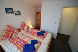 1 Schlafzimmer mit 2 Einzelbetten und blauen Kissen in der Unterkunft FeWo Palstek in Grödersby