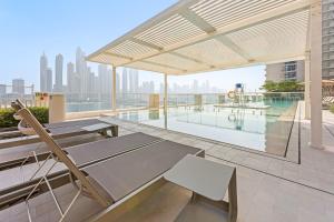 an outdoor patio with a pool on a building at Silkhaus Beach Vibes in Tower with Private Beach in Dubai
