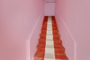 チェンナイにあるOYO Flagship 82883 YUME Staysの赤と白の床の客室の階段