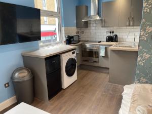 una cocina con lavadora y secadora. en Luxurious Restful Studio Flat, Less Than 30 Mins From Centre! en Londres