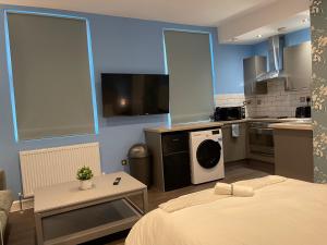 ein kleines Zimmer mit einem Bett und einer Küche in der Unterkunft Luxurious Restful Studio Flat, Less Than 30 Mins From Centre! in London