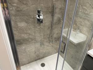 eine Dusche mit einer Glastür in einem Badezimmer in der Unterkunft Luxurious Restful Studio Flat, Less Than 30 Mins From Centre! in London + 13 Fotos