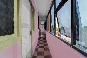 a hallway with pink walls and windows with a checkered floor at OYO Flagship 82883 YUME Stays in Chennai