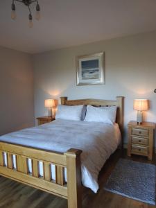 a bedroom with a large bed with two night stands at Ard Na Mara, Mullaghmore, Sligo in Mullaghmore