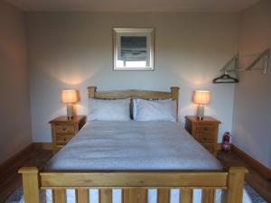 a bedroom with a wooden bed with two lamps at Ard Na Mara, Mullaghmore, Sligo in Mullaghmore