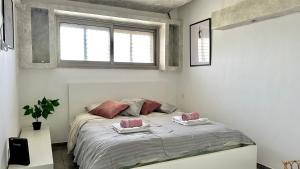 una camera con un letto con due cuscini sopra di Diamond 2bed apartment with jacuzzi by the sea a Haifa