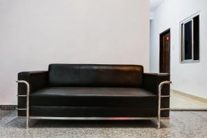 um sofá de couro preto sentado num quarto em OYO Hotel 99 em Rewāri