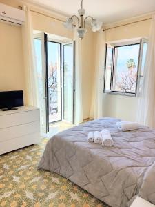 una camera da letto con due asciugamani su un letto con finestre di PARADISO a Salerno
