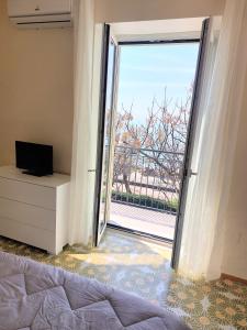 una camera con un letto e una grande porta scorrevole in vetro di PARADISO a Salerno