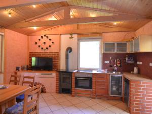 uma cozinha com fogão e uma televisão em Cosy apartment with covered porch em Finsterbergen