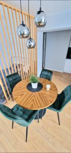 uma mesa de madeira com duas cadeiras e uma planta sobre ela em Studijos tipo būstas em Kretinga
