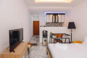 a bedroom with a bed and a desk with a television at Padma Amita Yogyakarta in Jetis