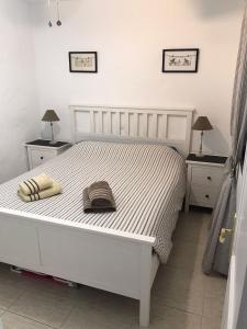 a bedroom with a white bed with two tables and two lamps at Sun Beach 14 Espino Castillo in Caleta De Fuste