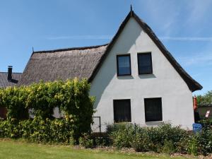 a white house with a thatched roof at Cosy Apartment in Pepelow near Baltic Sea in Pepelow