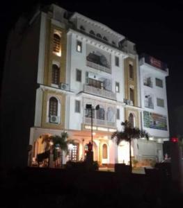 um grande edifício branco com luzes acesas à noite em Hotel Heritage em Jaipur