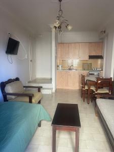 a living room with a couch and a table and a kitchen at Hotel Esperides in Kardamyli +37 photos