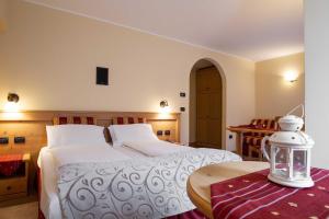 - une chambre avec un grand lit blanc et une table dans l'établissement Hotel Astoria, à Fiera di Primiero