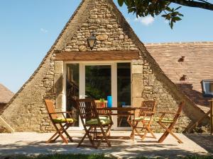 Peyzac-le-Moustier的住宿－Lovely cottage in Peyzac le Moustier with Terrace，石头房子里一组椅子和一张桌子
