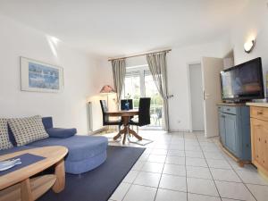 un soggiorno con divano blu e TV di Calm Holiday Home with Garden in Zingst Germany a Zingst