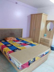 een slaapkamer met een bed met een quilt bij OYO Durga Palace in Sāngli
