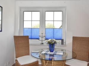 una sala da pranzo con tavolo in vetro e 2 sedie di Calm Holiday Home with Garden in Zingst Germany a Zingst